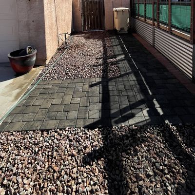 Charcoal paver side-yard walkway set through decorative rock, Arizona City