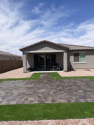 Paver patio and turf bands leading back toward the covered porch