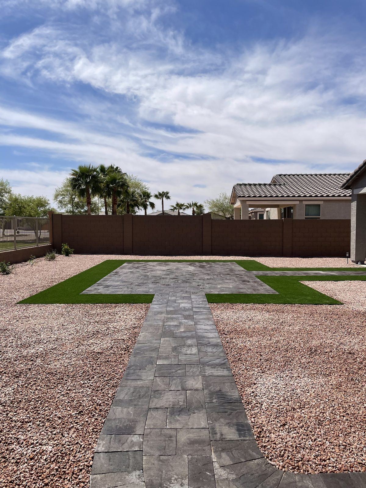 Artificial turf panels set between paver walkways in a desert backyard