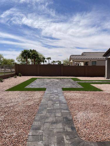 Paver walkway crossing decorative rock into the finished patio area