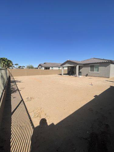 Empty backyard before renovation with layout marked out in orange paint