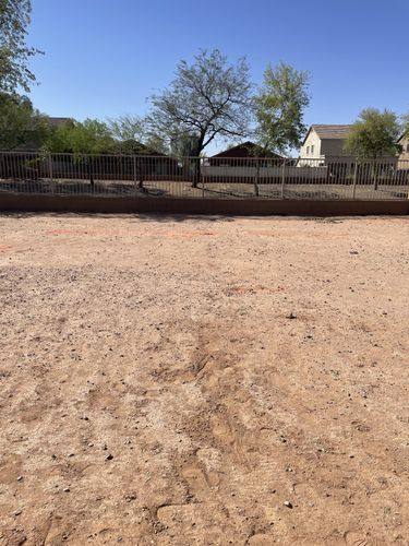 Bare dirt along the back block wall before plantings and irrigation