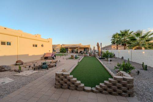 Bocce court walled in block running the length of the finished backyard at golden hour