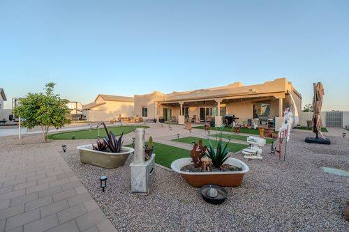Rear of the house with the putting green, turf panels, and paver walkways finished