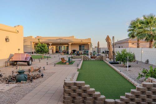Side yard with paver walkway, turf panels, and raised garden beds