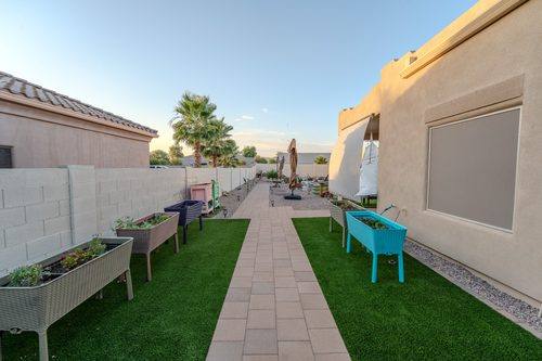 Overview of the finished yard showing walkways, turf, and the block-walled bocce court