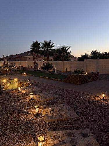Bocce court and lit stone urn feature after dark
