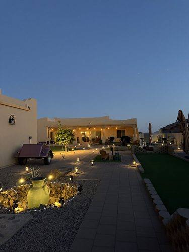 Stone urn water feature and paver walkway lit at night