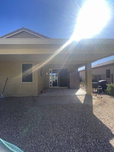 Covered patio before renovation with a small concrete slab and gravel underneath