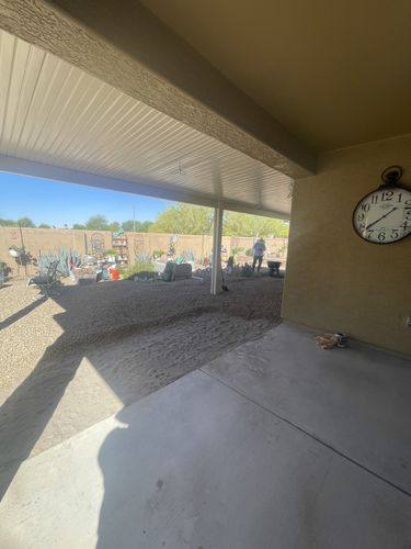 Bare concrete slab and gravel under the patio cover before renovation