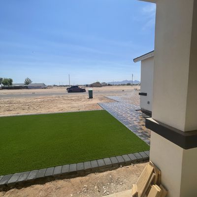 Front yard artificial turf panel with charcoal paver border at a new Eloy build