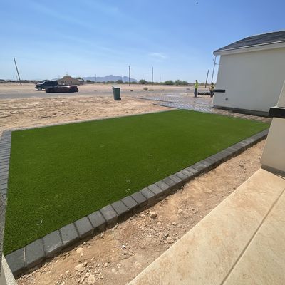 Artificial turf front lawn bordered in charcoal pavers, Eloy