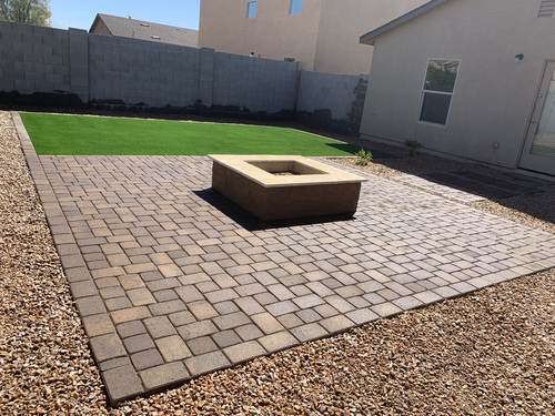 Paver patio with a built-in fire pit and artificial turf