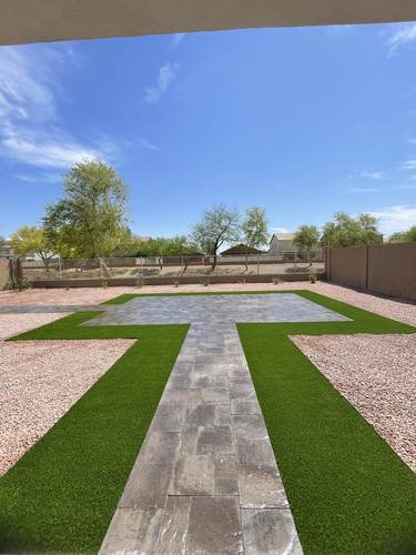 Paver walkway crossing through an artificial turf backyard