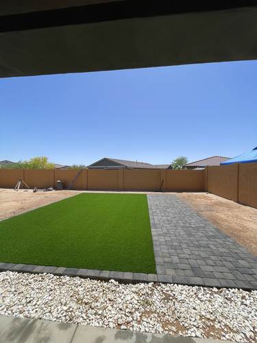 Artificial turf and paver walkway installation in progress