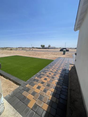 Paver walkway beside a new artificial turf lawn
