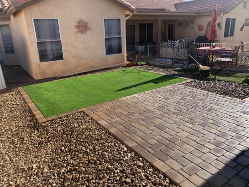 Backyard paver patio with artificial turf and gravel border