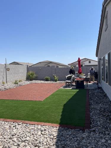 Backyard artificial turf with brick-style pavers