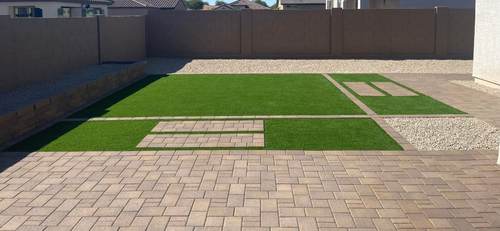 Backyard turf with decorative paver inlays and a full paver patio