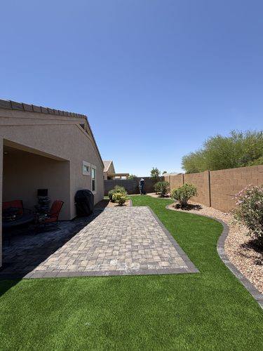 Slate gray paver patio alongside the curved artificial turf lawn