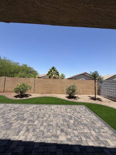 View from under the covered porch across the finished patio and turf