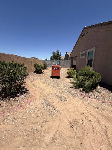 Side yard stripped to dirt with the layout marked in paint before construction
