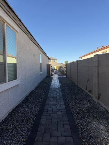 Side yard paver walkway set in black decorative rock
