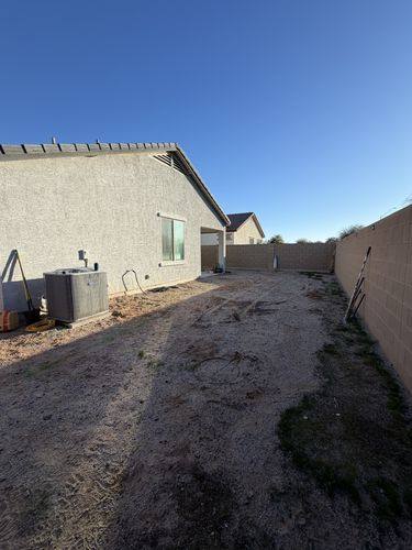 Empty dirt yard before renovation, past the AC unit