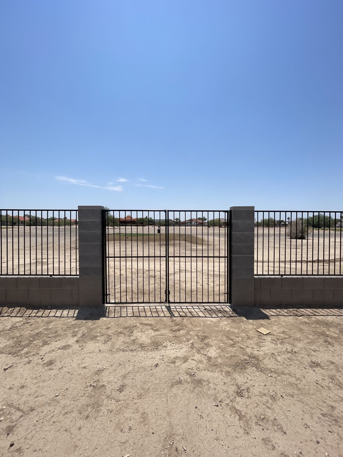 Double wrought iron gate set between block columns, Arizona City