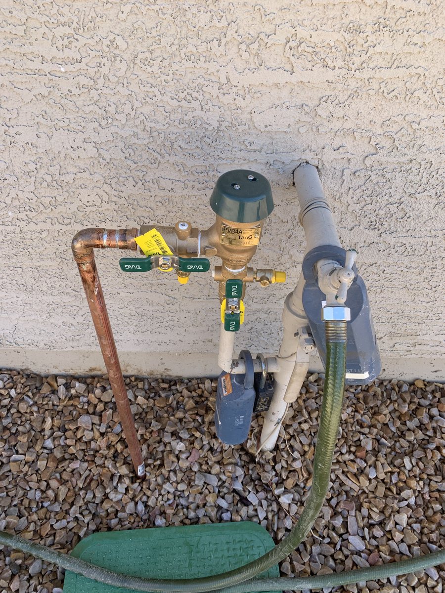 Brass pressure vacuum breaker and shutoff valves installed on an exterior wall