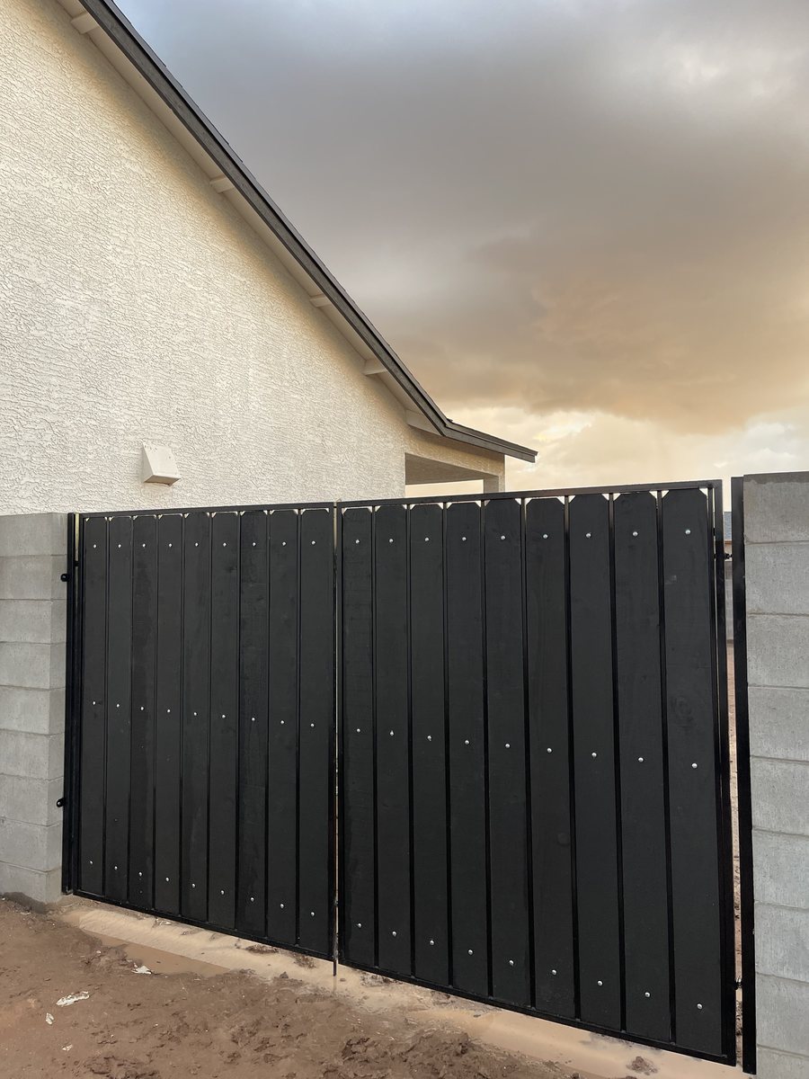 Double swing gate with a steel frame and wood infill set between block walls